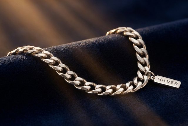 A Hilver silver chain with an engraved tag on navy velvet